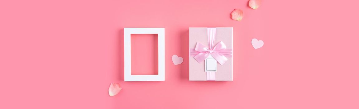 Valentine's Day design concept background with pink petals and gift box on pink background