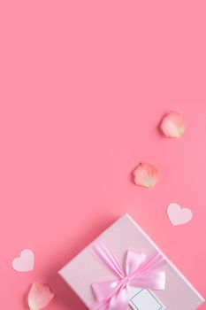 Valentine's Day design concept background with pink petals and gift box on pink background