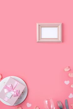 Valentine's Day design concept background with pink petals and gift box on pink background
