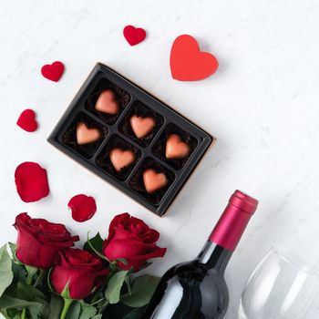 Top view of Valentine day chocolate with rose and wine, festive gift design concept for special holiday dating.