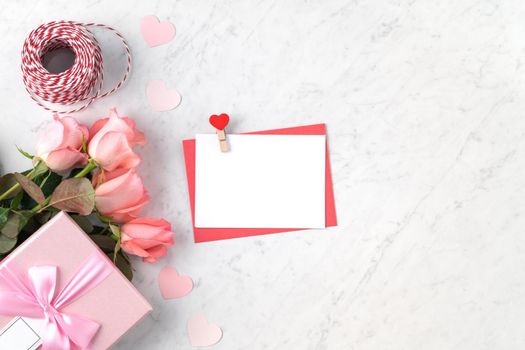 Valentine's Day design concept background with pink rose flower and gift box on marble white background