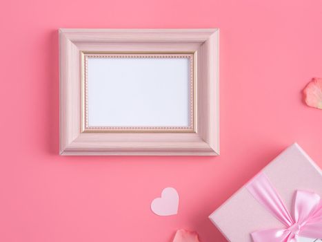 Valentine's Day design concept background with pink petals and gift box on pink background