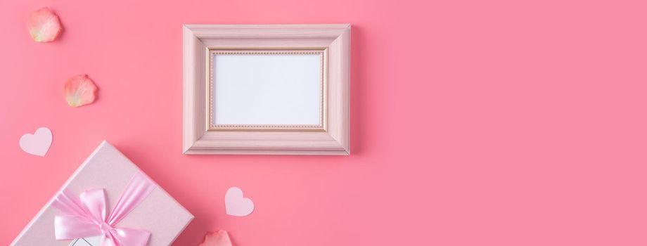 Valentine's Day design concept background with pink petals and gift box on pink background