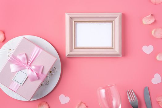 Valentine's Day design concept background with pink petals and gift box on pink background