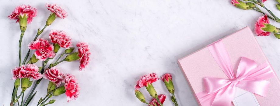 Top view of Mother's Day background design concept with carnation flower bouquet on marble table