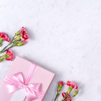 Top view of Mother's Day background design concept with carnation flower bouquet on marble table