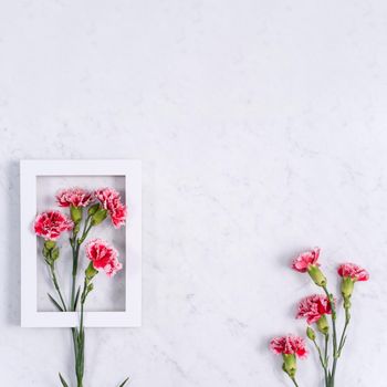 Top view of Mother's Day background design concept with carnation flower bouquet on marble table