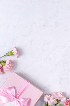 Top view of Mother's Day background design concept with carnation flower bouquet on marble table