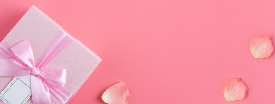 Valentine's Day design concept background with rose flower and gift box on pink background