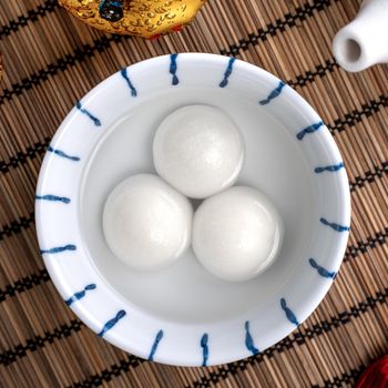 Top view of big tangyuan yuanxiao (glutinous rice dumpling balls) for Chinese lunar new year festival food, words on the golden coin means the Dynasty name it made.