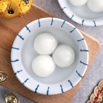 Top view of big tangyuan yuanxiao (glutinous rice dumpling balls) for Chinese lunar new year festival food, words on the golden coin means the Dynasty name it made.