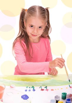 The child, a little girl draws paints