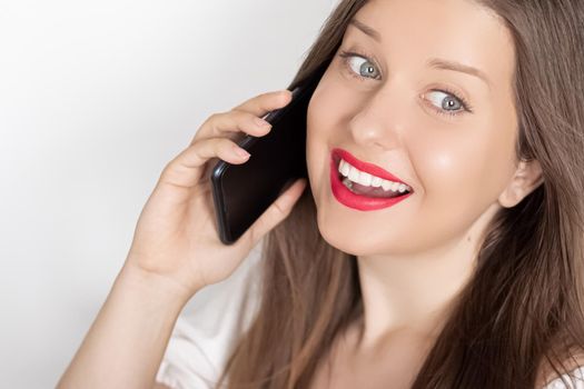 Happy smiling woman calling on smartphone, portrait on white background. People, technology and communication concept.