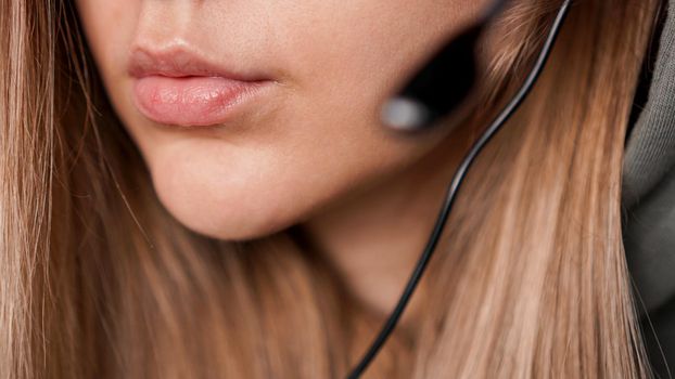 Closeup portrait of female lips and black headset. Call center or customer support. Focus on lips