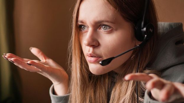 Confused girl operator with headset. Remote work from home in a call center. Irritable conversation with a client