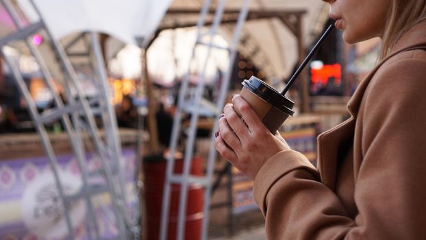 Young blonde with a cup of coffee. Woman at the food court. Lifestyle photo. Beautiful woman drinking coffee