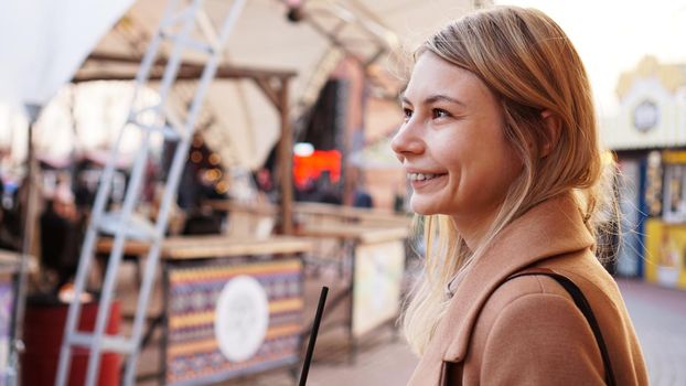 Portrait of a young woman in the city. City food court with street food. Portrait of a smiling blonde. Lifestyle photo