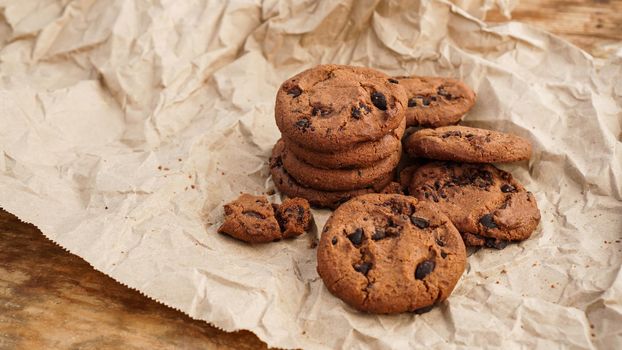 Flatview of handcrafted chocolate cookies with chocolate chips on baking paper. Natural handmade organic snakes for healthy breakfast