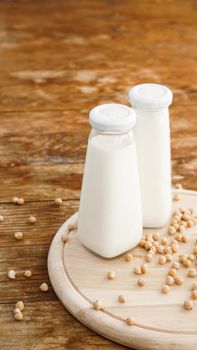 Soy milk and soy bean it on wooden background, healthy concept. Protein of Soy. Vertical photo