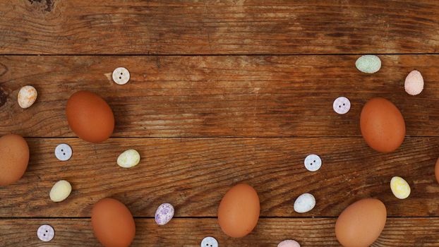 Eggs on a wooden rustic background with copy space for text. Fresh chicken eggs and decorative eggs for Easter decoration.