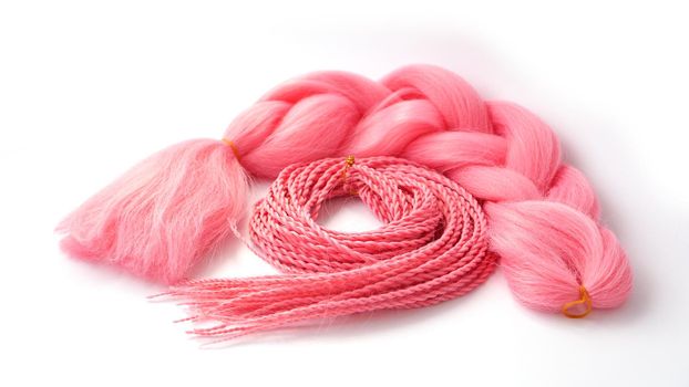 Pink kanekalon hangs and braids on a white background. Photo for catalog or hairdresser