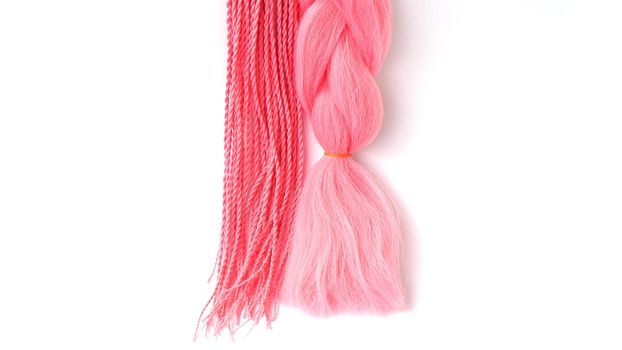 Pink kanekalon hangs and braids on a white background. Photo for catalog or hairdresser