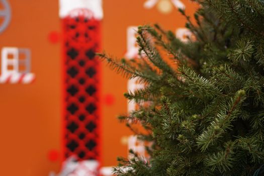 Branches of spruce close up, part of a living conifer without frills and people on brown decorations of New Year city for children