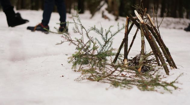 Tourists at a halt. Preparation for making a fire from spruce branches. Winter forest