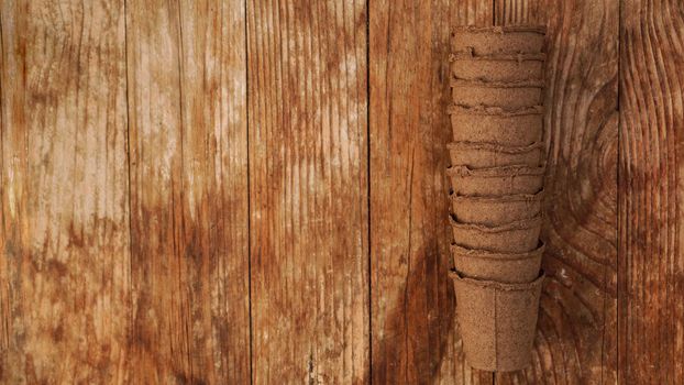 Empty peat pots for seedlings on a wooden background. Gardening. The concept of preparing garden tools for the spring planting of plants and flowers