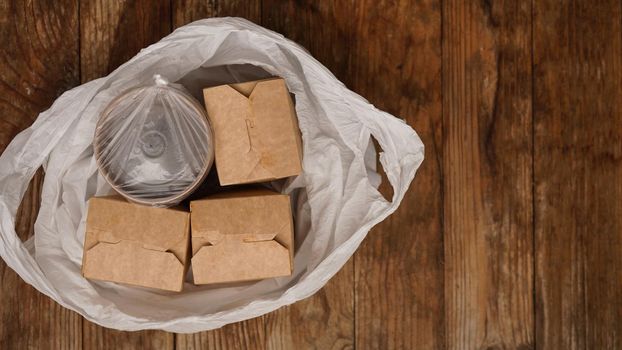 Asian food delivery. Food in containers and in a package on a wooden background. Japanese food and sushi packaging.