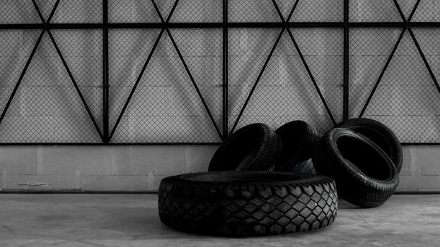 Tire warehouse. Four tires on the concrete floor. Black mesh on the wall. Brutal photo