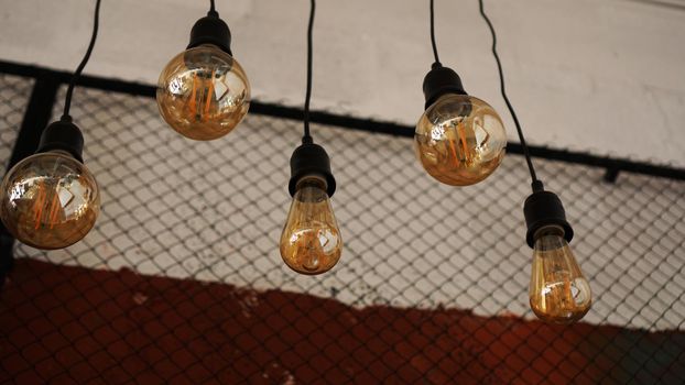 Decorative antique edison style light tungsten bulbs against the background of the wall with black mesh