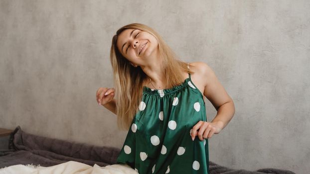 Beautiful smiling blonde in green pajamas. Good happy morning concept