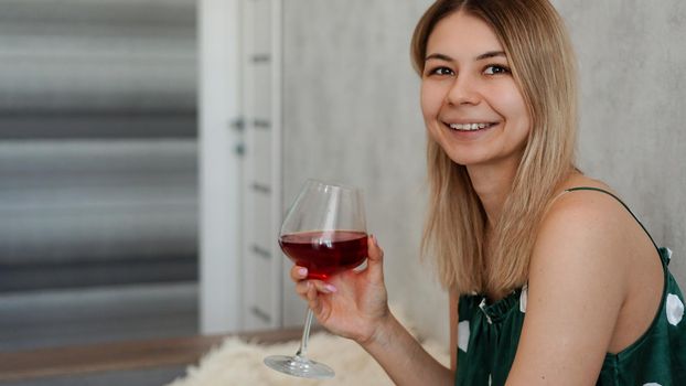 Girl in green pajamas in bed with a glass of red wine. Morning wine in bed