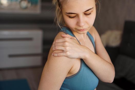 Women wearing athletic suits feeling shoulder pain after exercise at home. The danger of self-training