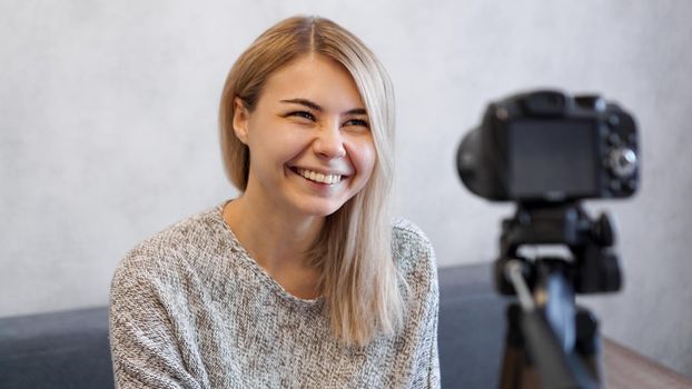 Cheerful female blogger recording video at home