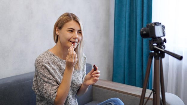 A beauty blogger or video blogger tells and shows subscribers how to do makeup. Young woman paints lips