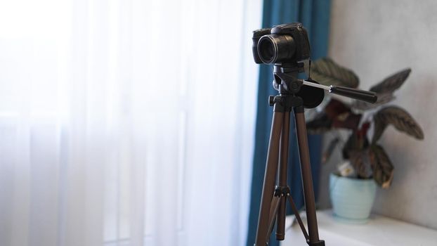 Camera on a tripod indoors. Filming a video blog or photographing at home - no visible brands.