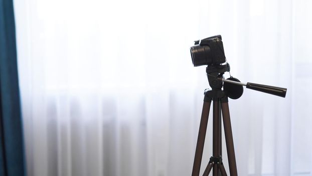 Camera on a tripod indoors. Filming a video blog or photographing at home - no visible brands.