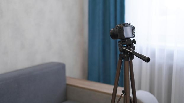 Camera on a tripod indoors. Filming a video blog or photographing at home - no visible brands.