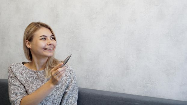 The woman shows with a pen on a gray wall. Place for information - graphics, inscriptions, banners