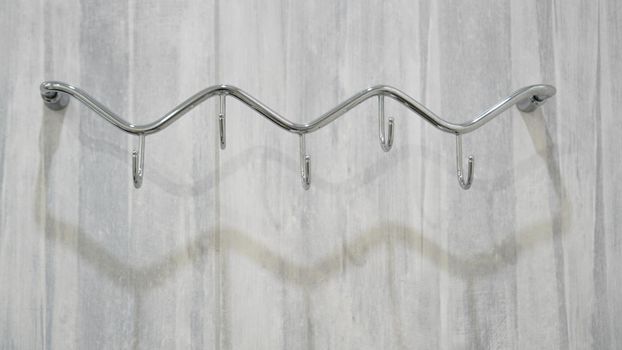 Metal adhesive hooks on gray background. Towel hangers