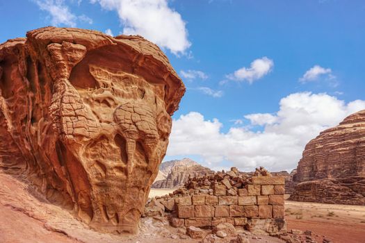 Stone bricks wall remains with rocky cliffs near on Wadi Rum desert near Lawrence's Spring tourist spot.