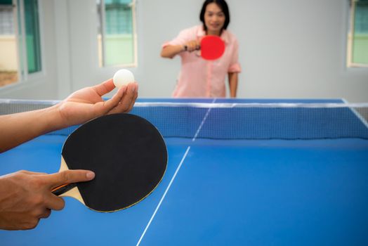 Adult Asian woman are waiting to start playing table tennis or Ping pong indoor. Leisure with competing in sports games in the house, Recreation or exercise stay at home with the family in Thailand