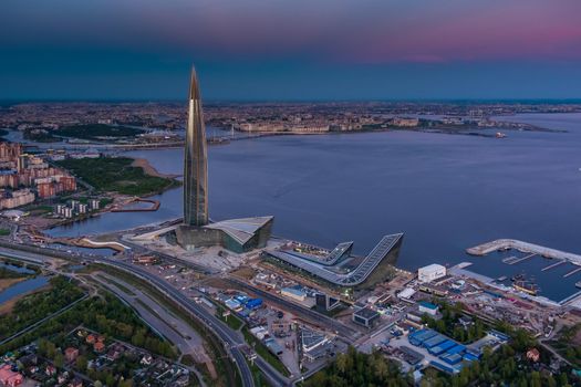 Russia, St.Petersburg, 16 May 2021: Drone point of view of highest skyscraper in Europe Lakhta Center at pink sunset, Headquarters of the oil company Gazprom, stadium Gazprom Arena on background. High quality photo