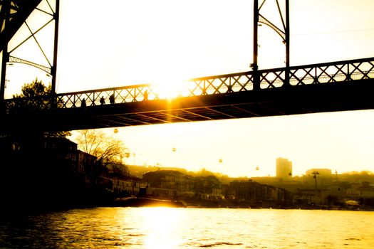 Beautiful and colossal iron bridge called Dom Luis I over the waters of the Douro River in Porto at sunset