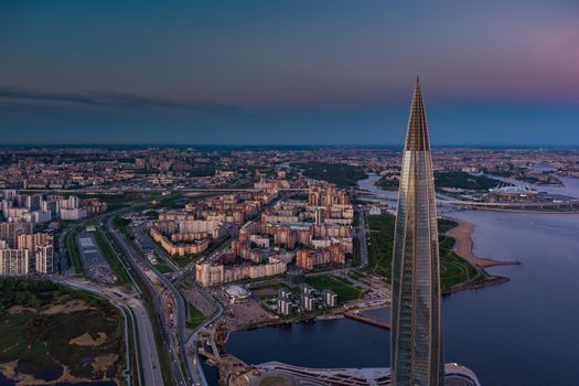 Russia, St.Petersburg, 16 May 2021: Drone point of view of highest skyscraper in Europe Lakhta Center at pink sunset, Headquarters of the oil company Gazprom, stadium Gazprom Arena on background. High quality photo