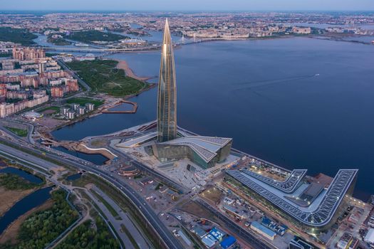 Russia, St.Petersburg, 16 May 2021: Drone point of view of highest skyscraper in Europe Lakhta Center at pink sunset, Headquarters of the oil company Gazprom, stadium Gazprom Arena on background. High quality photo