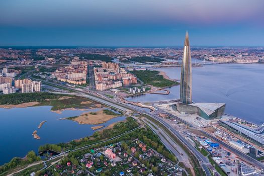 Russia, St.Petersburg, 16 May 2021: Drone point of view of highest skyscraper in Europe Lakhta Center at pink sunset, Headquarters of the oil company Gazprom, stadium Gazprom Arena on background. High quality photo