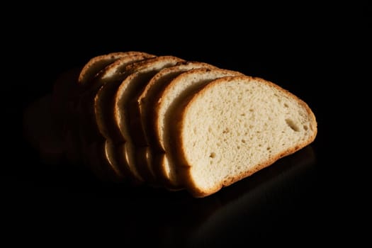 Slices of white bread on a dark background close up